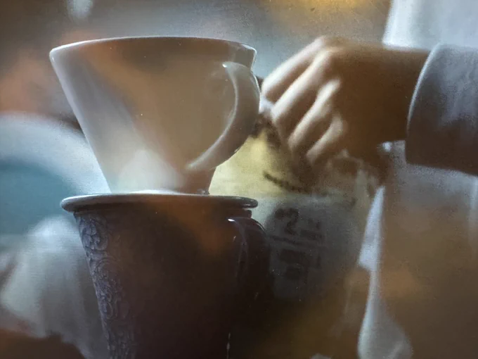 Screen shot of coffee cup with cone filtering coffee on top and bag of paper filters