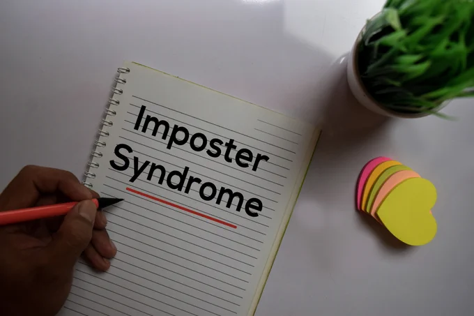 Photo of the word 'Imposter Syndrome' written on paper.