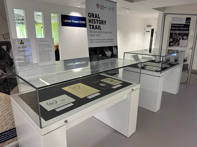 Glass archival display cases featuring materials from the Occupational and Environmental Diseases Association (OEDA) Archives at the University. 