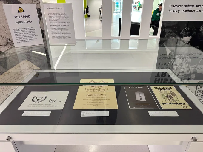 Glass archival display cases featuring materials from the Occupational and Environmental Diseases Association (OEDA) Archives at the University.  