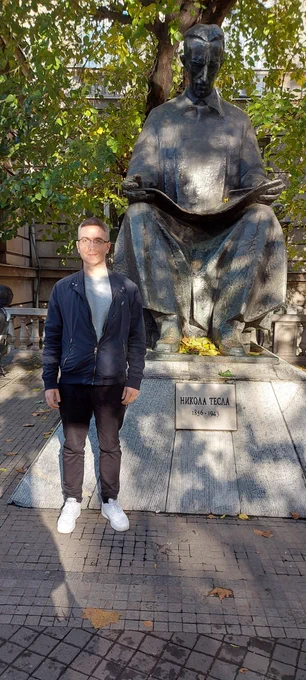 Research scientist Marko Njegomir next to the statue of Nikola Tesla in front of ETF in Belgrade.
