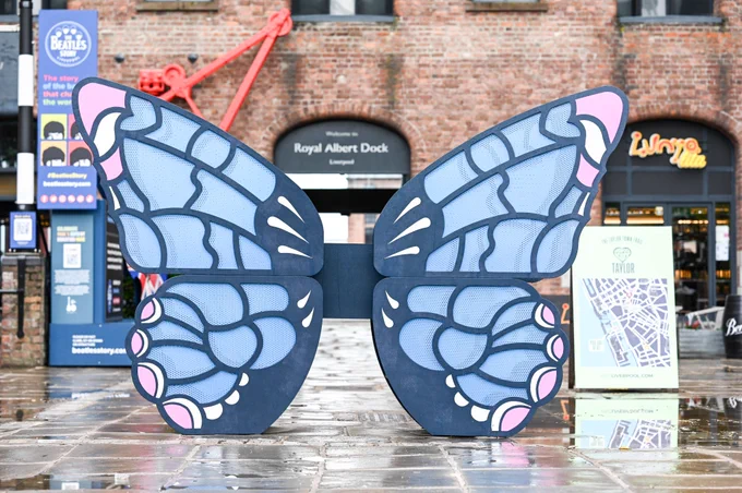 A large, outdoor art installation and photo-spot featuring large blue butterfly wings.