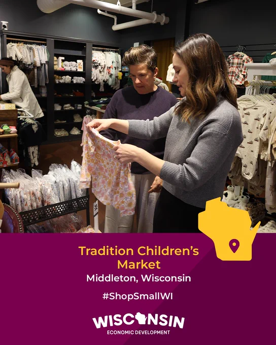 Two people examining children's clothing at Tradition Children’s Market in Middleton, Wisconsin. #ShopSmallWI