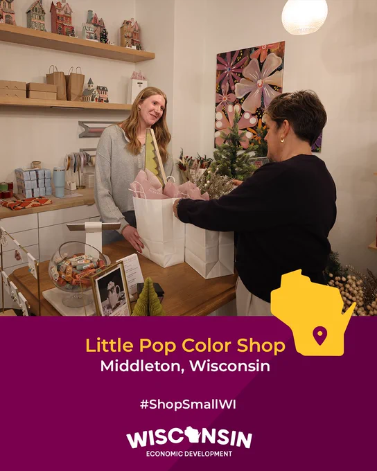 Two individuals at Little Pop Color Shop in Middleton, Wisconsin, one handing over a light pink gift bag to the other in a warmly decorated store. The image includes the logo of Wisconsin Economic Development and the hashtag #ShopSmallWI.