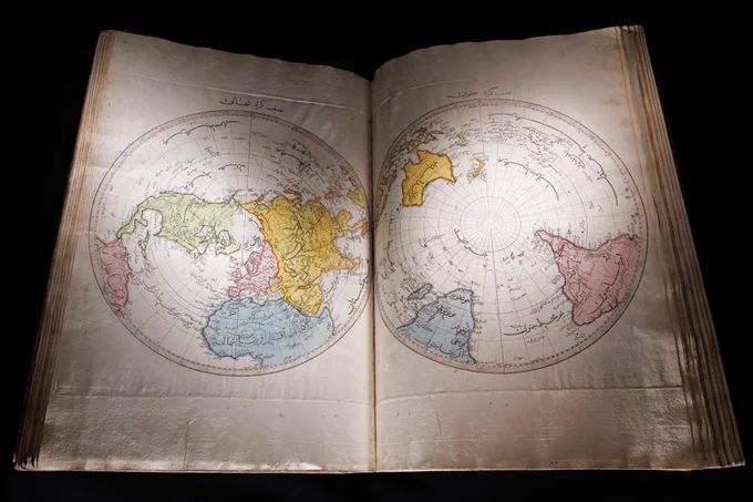 The Cedid Atlas Tercümesi, a distinctly Ottoman world atlas, lays open showcasing two colourfully engraved circular maps.