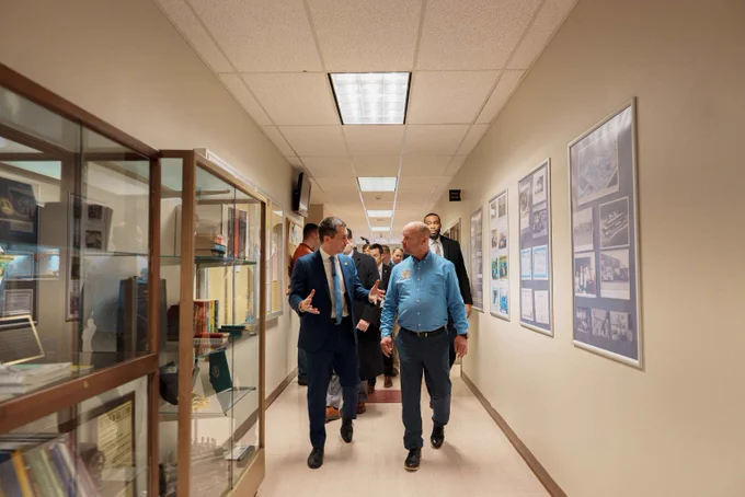 Secretary Pete and an instructor walking in the hallway at an IBEW Training Facility. 
