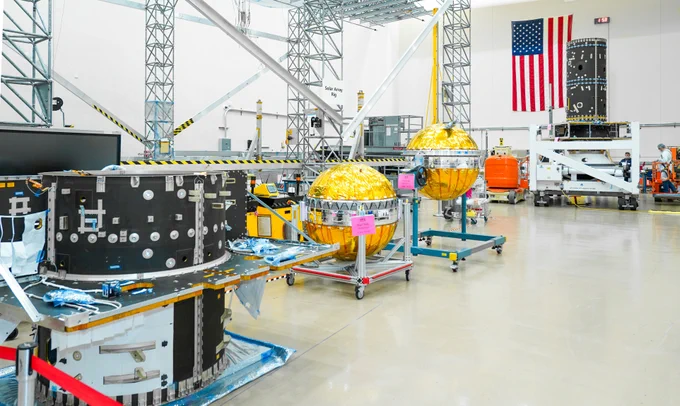 
Power and Propulsion Element hardware for the Gateway lunar space station, including its primary structure and fuel tanks, is displayed in a facility at Maxar Space Systems in Palo Alto, California. The components are organized for assembly, with an American flag visible in the background. Credit: Maxar Space Systems