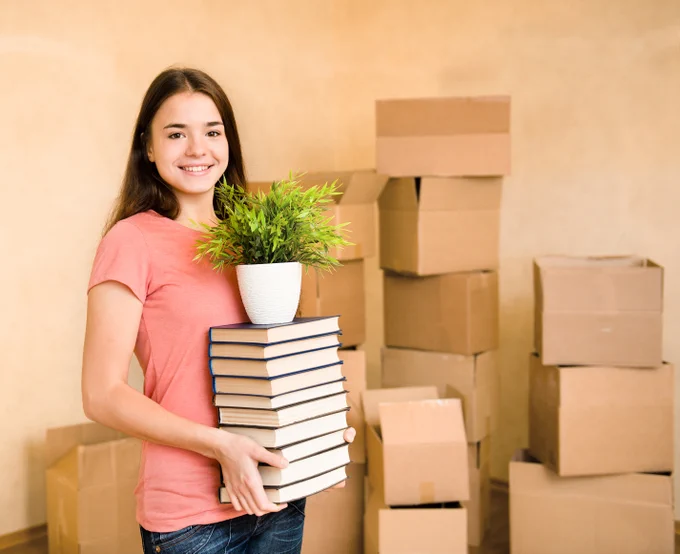 Smiling teen unpacking in her new apartment
