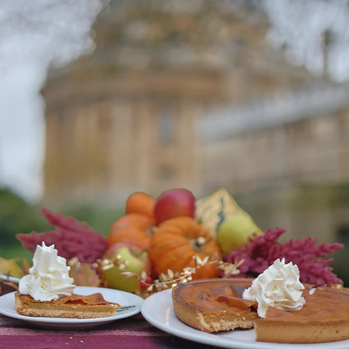 Pumpkin pie in front of some autumnal gourds with the Radcliffe Camera in the background.