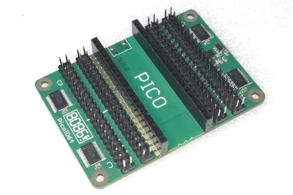 A green rectangular PCB with two 1x10 sockets in the middle to plug in a Raspberry Pi Pico and 2 rows of 2x20 header pins each side of them to access the 64 I/O lines.