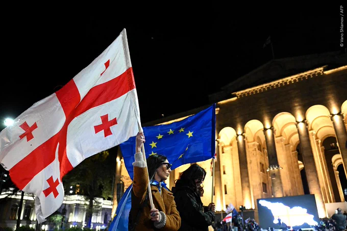Protesters with one woman holding a Georgian flag and another an EU flag