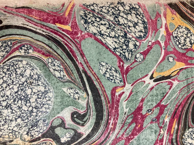 CHS 339 Marbled Endpapers 1: Marbled endpapers in swirls of black, green, reddish purple, and cross-hatched black and white splodges. 