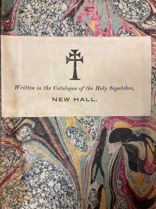 CHS 339 Marbled Endpapers and Bookplate: Marbled endpapers in swirls of black, green, reddish purple, and cross-hatched black and white splodges with a bookplate with black double-barred cross and text beneath reading “Written in the Catalogue of the Holy Sepulchre, New Hall”.