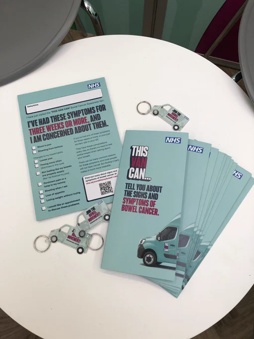 A white table on the bowel cancer awareness van with awareness leaflets and keyrings.