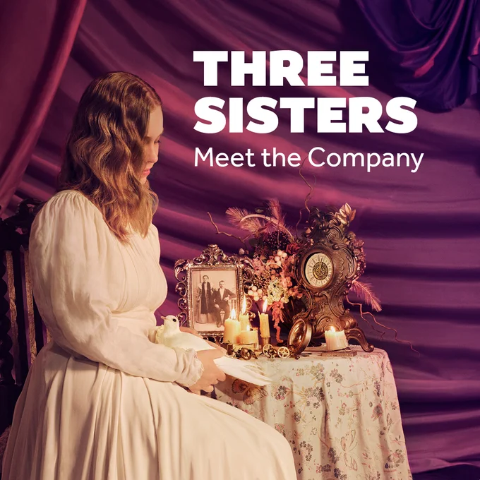 A woman wearing a white dress sits at a table. Her blond hair obscures her face. She holds a white dove in her hands. On the table next to her are a conglomeration of objects: a picture frame, a Victorian clock, candles, and a flower arrangement. Text reads: THREE SISTERS Meet the Company'.