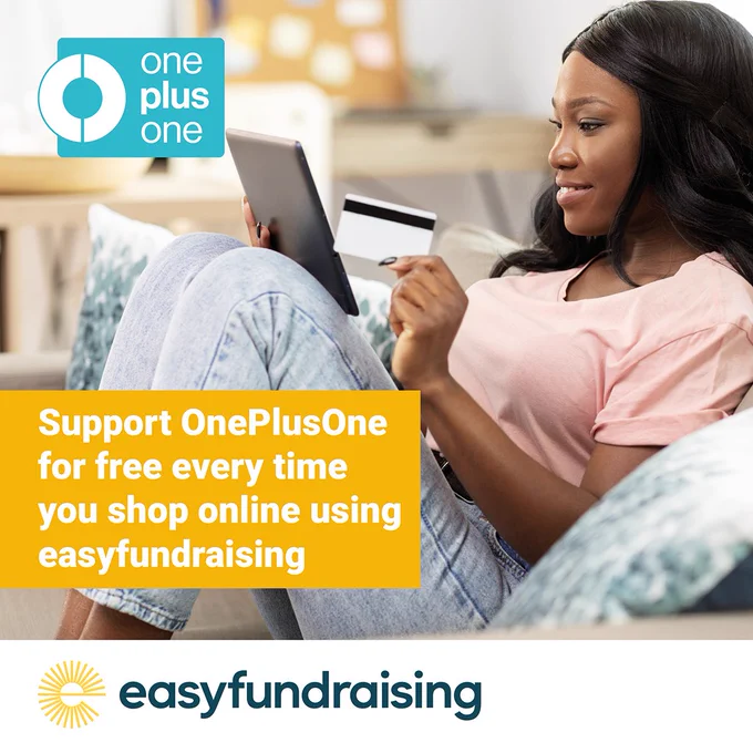 Image shows a woman sitting on a sofa smiling at the screen on an electronic tablet device, holding a credit card in her hand as if she is happily shopping online. There is a OnePlusOne logo in the top left hand corner and the words read, 'Support OnePlusOne for free every time you shop online using easyfundraising.' There is also an easyfundraising logo at the bottom of the image.