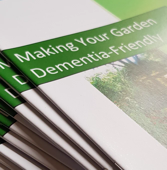 decorative image showing a stack of our ‘Making Your Garden Dementia-Friendly’ booklets