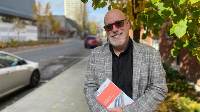 Éric Dionne, professeur à la Faculté d’éducation, qui sourit, dehors.