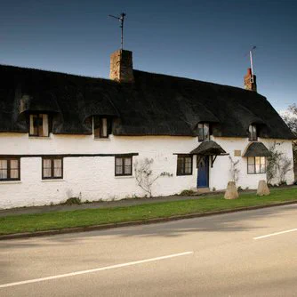 Long low white cottage with dark roof