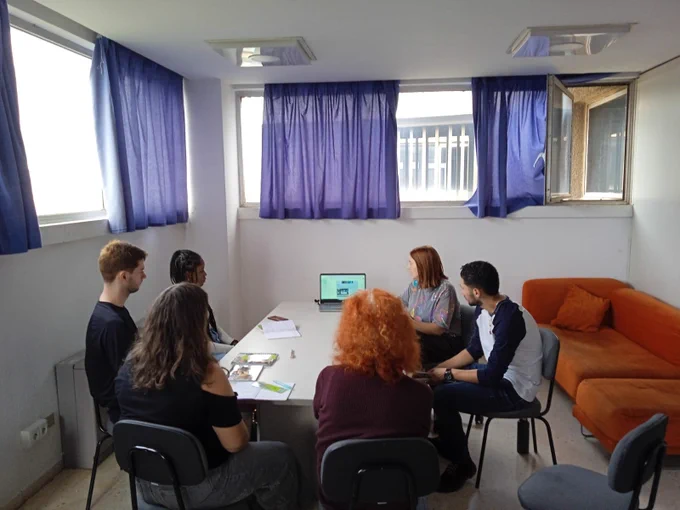 Students sitting around a table in a room 