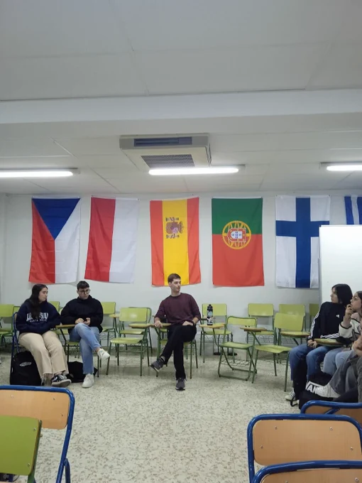 Students sitting in a classroom with country flags hanging on the wall