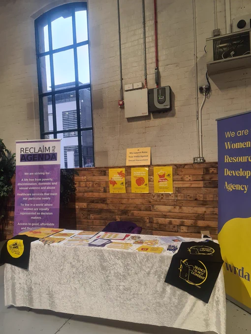 A table covered in raise your voice materials with the wrda Nd reclIm the agenda pop ups either side. 