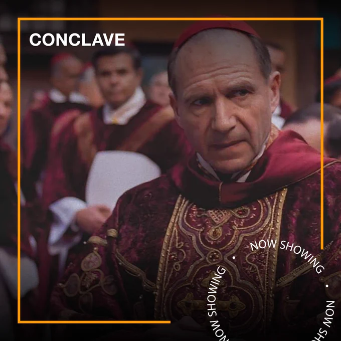 Ralph Fiennes dressed as a member of the Catholic Church in Conclave. Text - Conclave, Now Showing