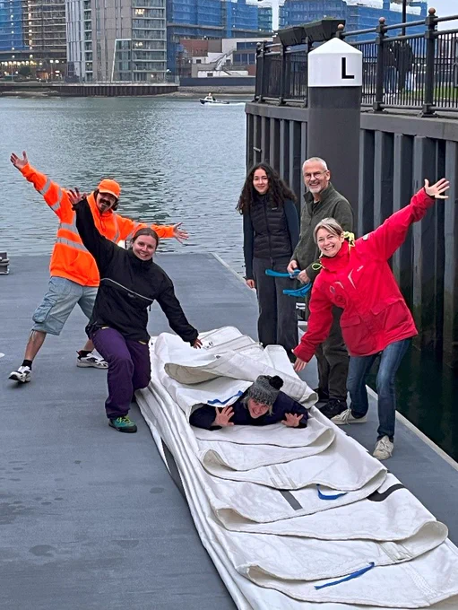 Celebrating a beautiful sail flake on the pontoon ... even if one of the team seems set to get rolled up into the sail ...