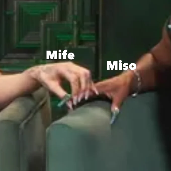 [Image description: Ariana Grande and Cynthia Erivo's hands, labeled Mife and Miso, gently touching hands, with a green, ornately designed background.]
