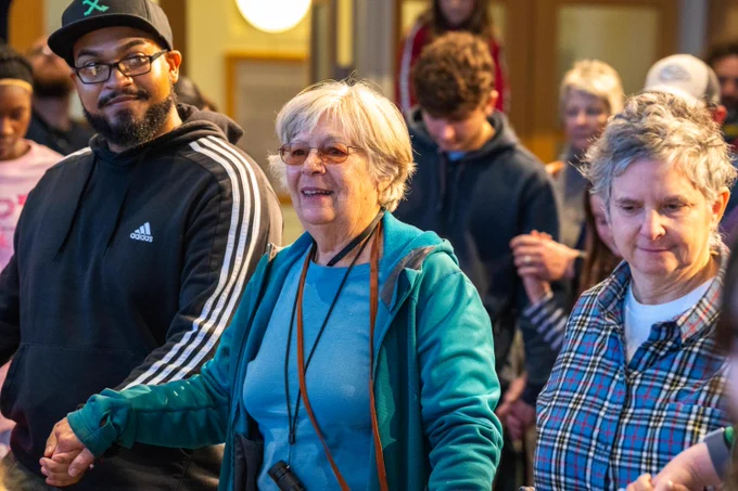Group of diverse people smiling and dancing together at the JFK Library.