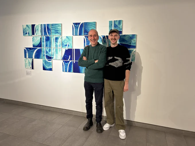 Photograph of Paul Aston (left) and Conor Foran (right) standing in front of their collaborative piece ‘Shaping Fluency’