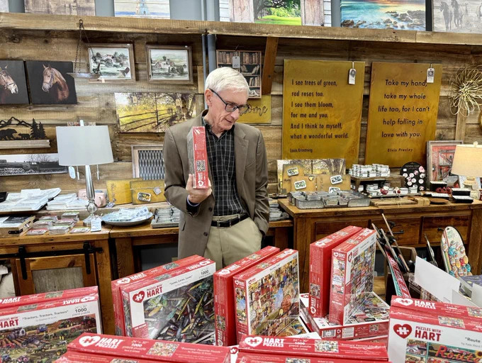 Gov. Evers looks at puzzles while shopping small.