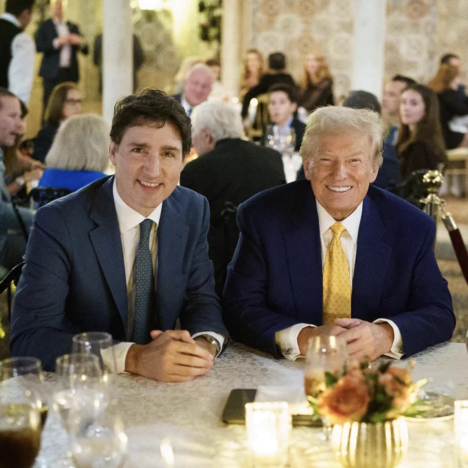 Prime Minister Justin Trudeau and President Donald Trump are sitting next to each other at a dinner table in Palm Beach, Florida. 