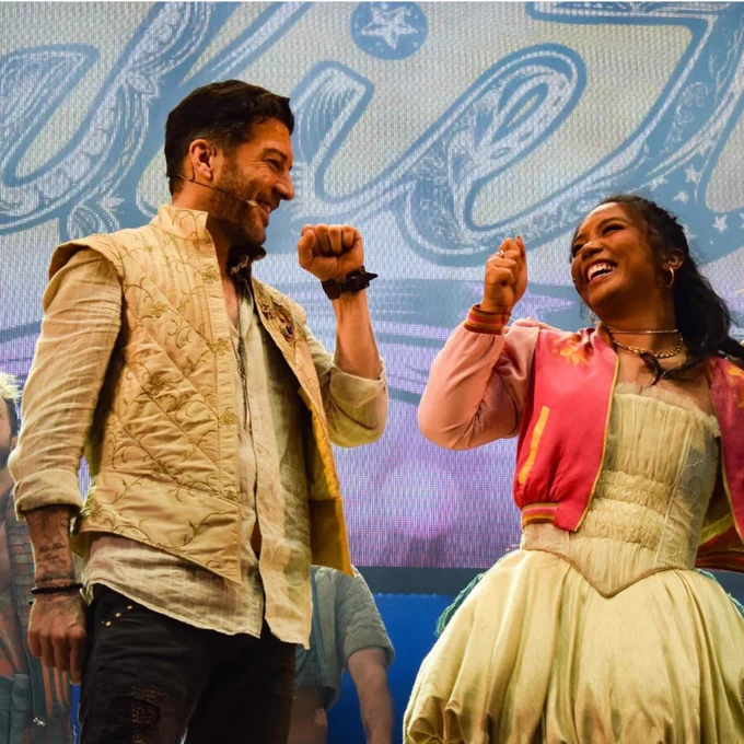 Matt Cardle and Gerardine Sacdalan onstage in the bows, smiling at each other and fist bumping.