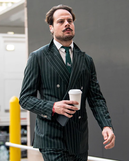 Auston Matthews walking into Amalie Arena in a dark green suit with pinstripes on it.