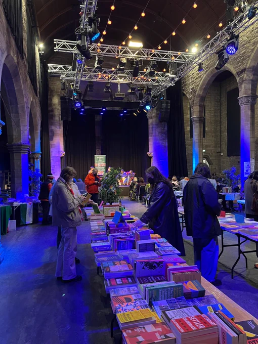 Book fair in dark blue light, people browing books