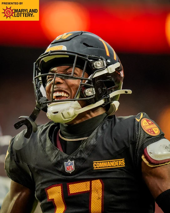 Photo of Terry McLaurin smiling during the Titans game. He is wearing a black helmet and black jersey.