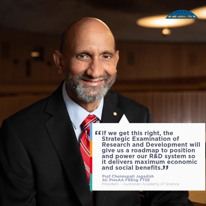Person in a suit smiling at the camera in a conference room, with a quote about research and development by Prof. Chennupati Jagadish, President of the Australian Academy of Science.