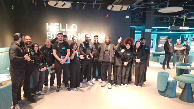 Our team smile for the camera in our new store in front of the Hello Birmingham welcome sign writ large on the wall