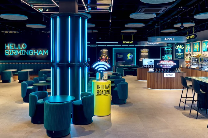 A wide shot of the store showing the Gaming Zone, customer seating, Apple and Samsung products and more.