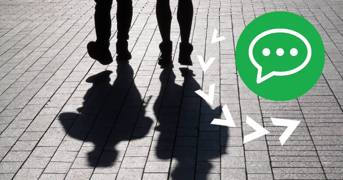 Silhouettes of two figures on a grey pavement