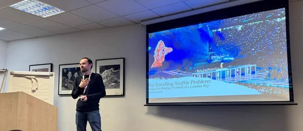 Me, presenting the title slide of my Travelling Swiftie Problem talk, featuring a photo of Taylor Swift performing live on tour.