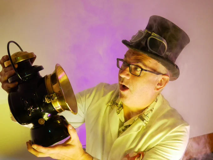 Professor Pickle in a black top hat and lab coat looks shocked at an old Lucas lamp