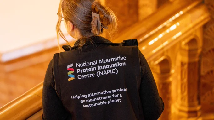 The back of someone's jacket which says "National Alternative Protein Innovation Centre (NAPIC): Helping alternative proteins go mainstream for a sustainable planet"