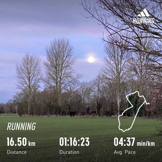 Moon in the morning sky over some trees and field. Running stats superimposed: 16.5km, 1:16:23