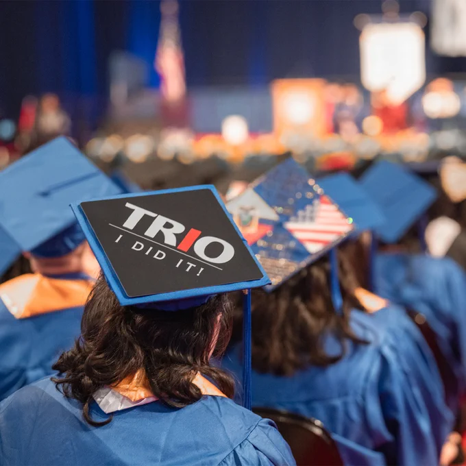 Graduates in blue regalia as seen from behind
