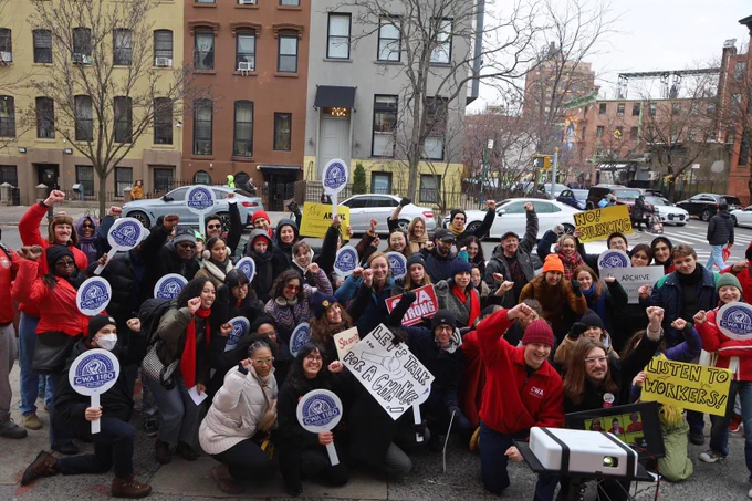 Rally photo- crowd of people holding signs and raising fists