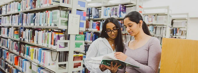 Students looking at books in Greenfield Medical Library