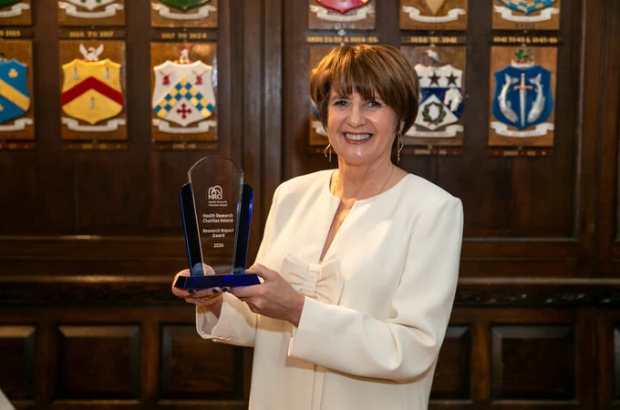 Professor Mary McCarron holds her 2024 HRCI Research Impact Award at a ceremony in the Mansion House in Dublin.