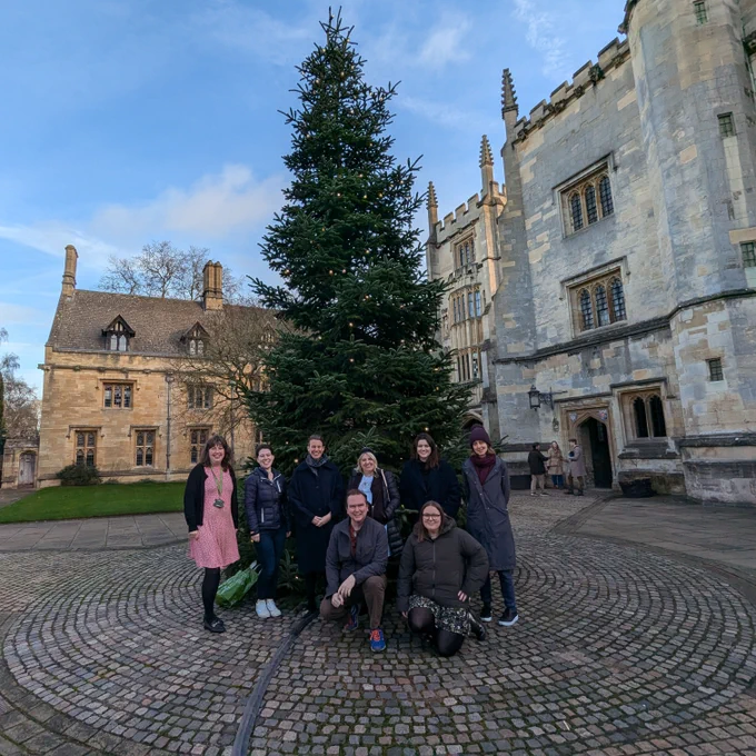 Photograph of library and archives team members, in St John’s Quad, Magdalen College, next to Magdalen’s Christmas Tree.